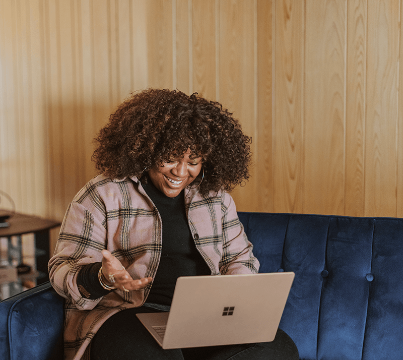 Amplify Your Practice Level 3 Image - Happy woman on couch with laptop